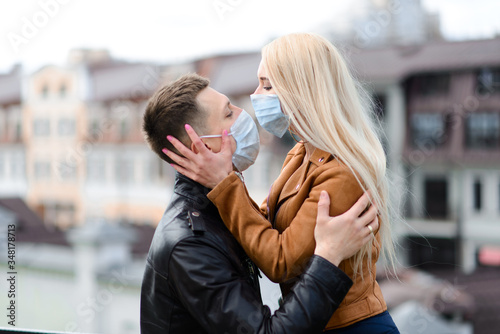 Young couple in love in protective medical mask on face outdoor at street. Environmental pollution concept. Guy and girl in virus protection