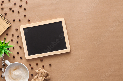 Black board mockup. Coffee and scattered beans on a brown background.