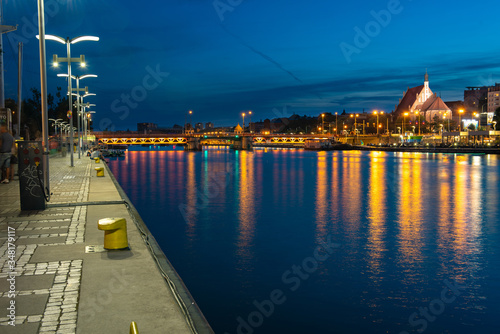 Szczecin. Night view from across the river to the illuminated historic center. Odra river. Chrobry embankments in Szczecin