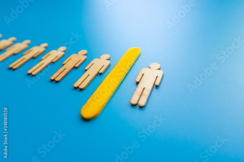 Selected wooden figure on blue background. The concept of finding an employee in business. HR manager search employee. Group leader.