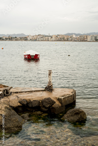 Small jetty and artisanal fishing boat on a beach in Aguilas, Murcia, Spain.