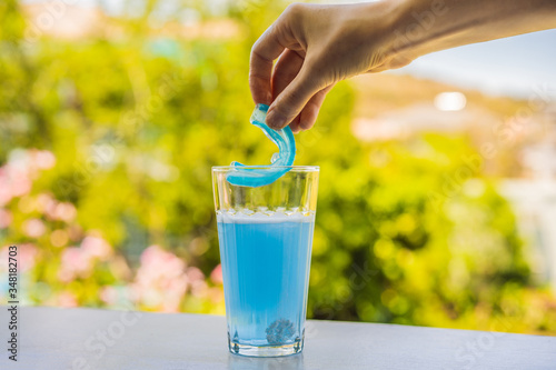 Foto Dental mouthpiece cleaning tablet in a glass