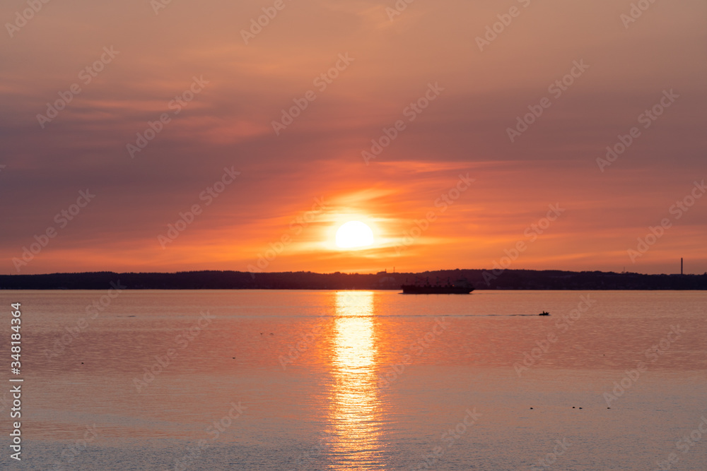 Beautiful red orange sunset with reflection over Oresund and the island of Ven. Photo taken from Glumslovs backar in Glumslov, Sweden.