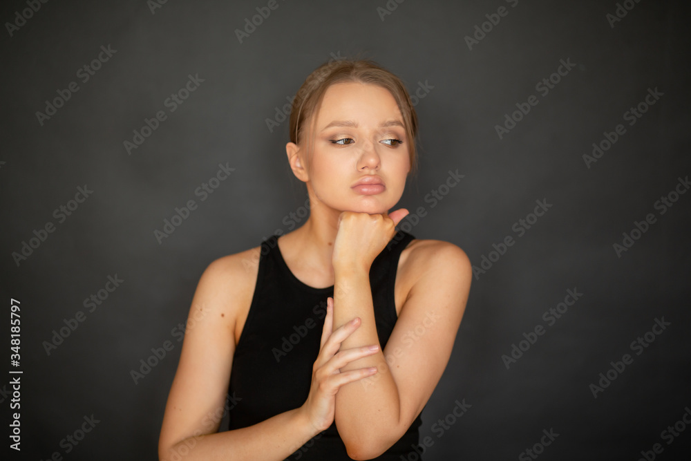 beautiful, lovely girl thought on a dark background in the studio. emotions beautiful, lovely girl thought on a dark background in the studio. emotions