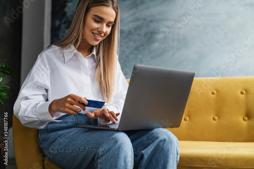 Female using bank card to pay for goods purchased online. Safe payment services for customers of worldwide retailers.