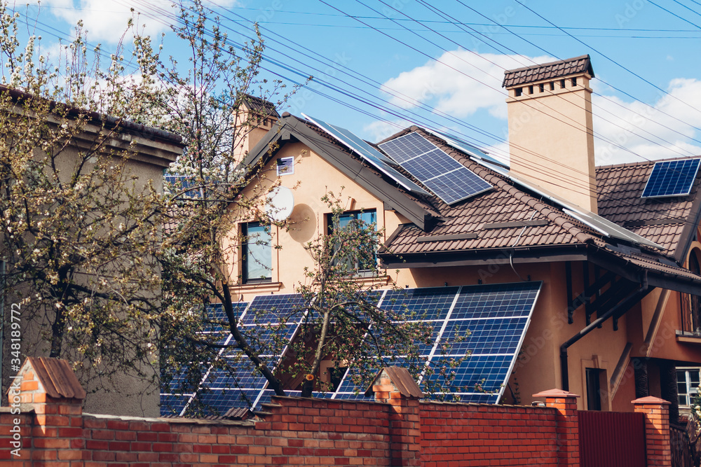 Residential house with solar panels on roof. Alternative energy. Using sun power for home. Conservation