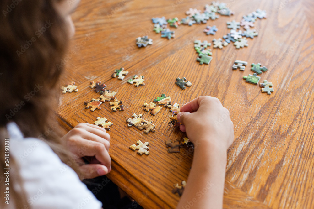 The girl collects pieces of them to make a picture, puzzles, mind development, skills, understanding, playing, spending time, communicating with parents, mom The girl collects pieces of them to make a picture, puzzles, mind development, skills, understanding, playing, spending time, communicating with parents, mom