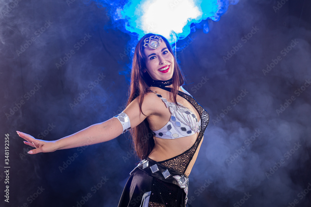 Girl dancing belly dance, fusion or tribal. A woman in a beautiful costume demonstrates charming and gentle movements in the dance. Girl dancing belly dance, fusion or tribal. A woman in a beautiful costume demonstrates charming and gentle movements in the dance.