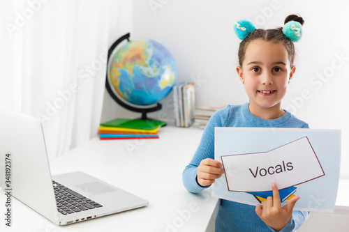 Foto Little girl at speech therapist office, little girl learns vocal on laptop onlin