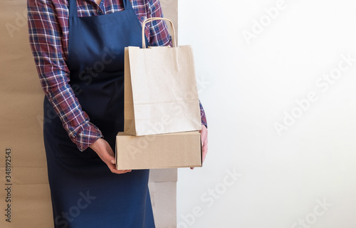 Worker delivery service packing bag box apron packer shipping open coffee to go copy space