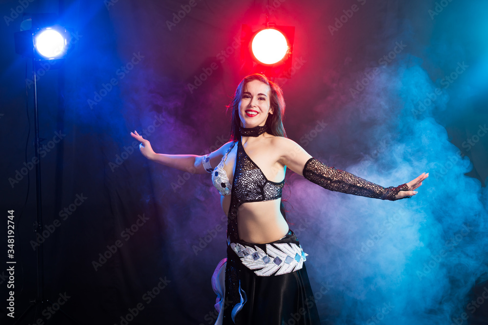 Young woman dancing in Tribal Fusion style. Belly dance on the stage.