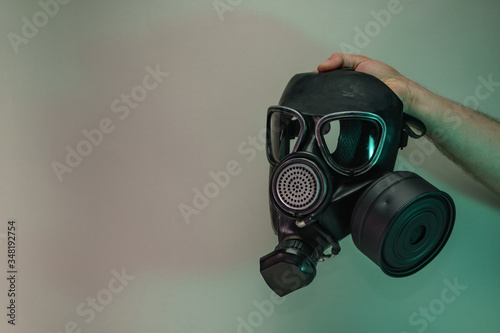 Hand hold black old gas mask in the color light. Beautiful old minimal in neon light. Minimalism retro style concept. Background pattern for design.