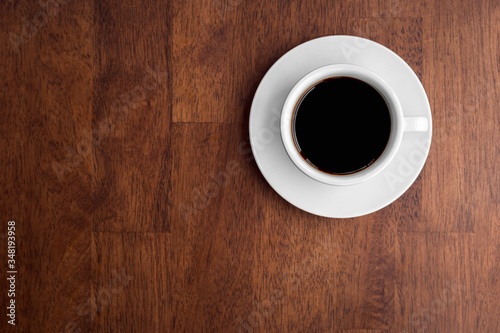 Top view of black coffee on wooden background.