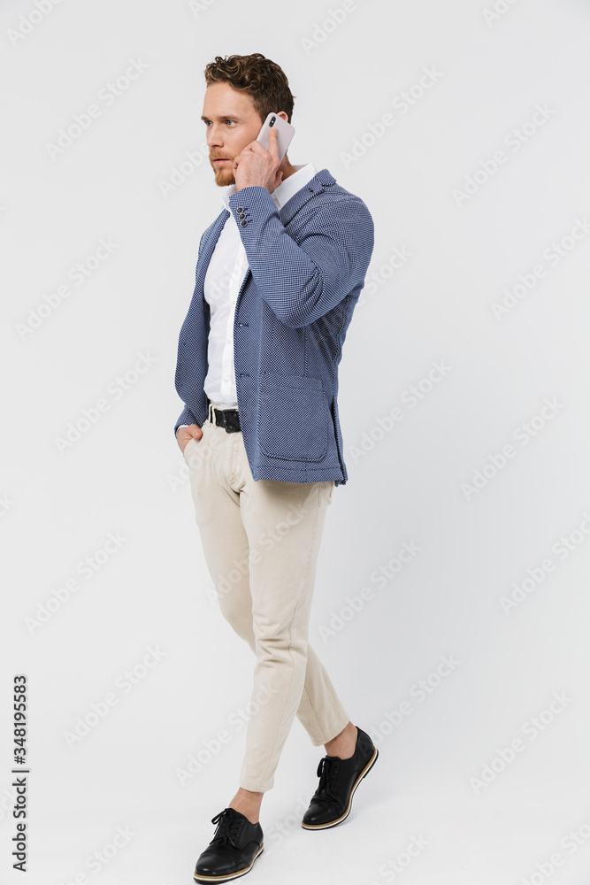 Image of brutal serious man wearing jacket talking on smartphone