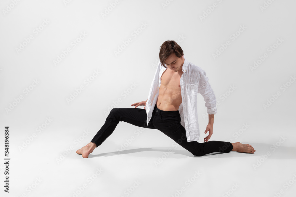 Young and graceful ballet dancer in minimal black style isolated on white studio background. Art, motion, action, flexibility, inspiration concept. Flexible caucasian ballet dancer, weightless jumps.