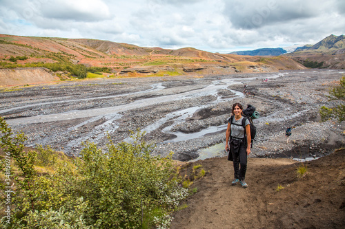 Obraz na płótnie A young woman arriving at some cold rivers on the 4-day trek from Landmannalaugar. Iceland w salonie