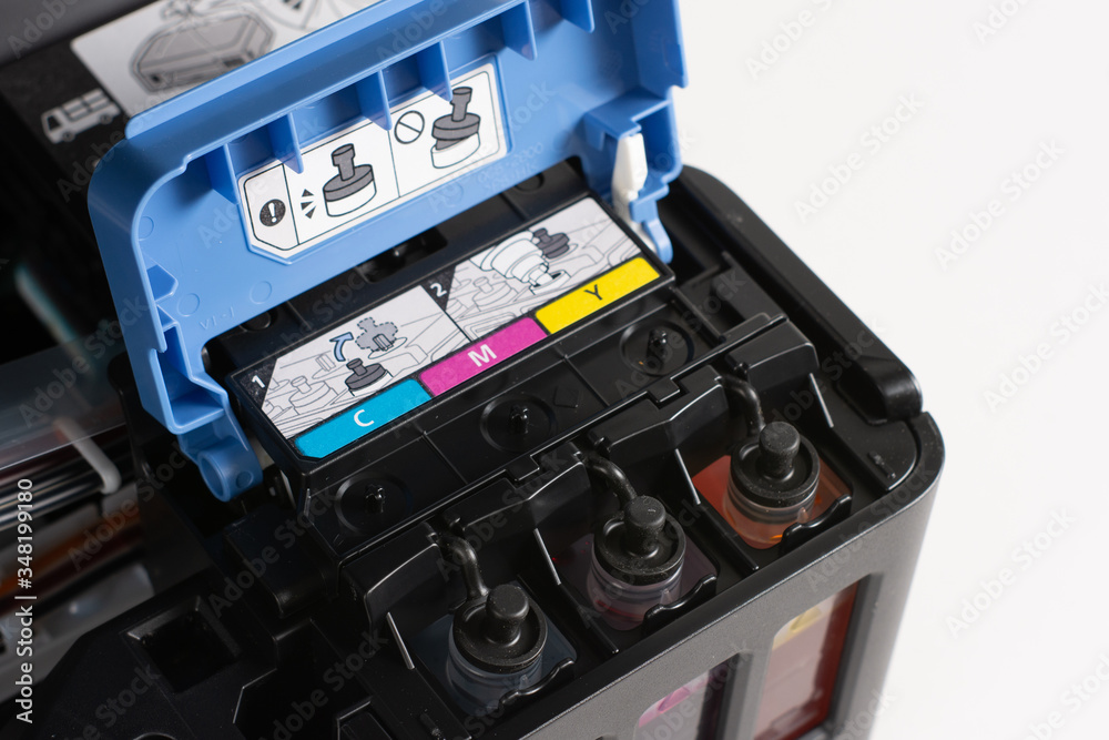 Up close, ink tanks from a printer displaying CMYK Cyan, Magenta ...