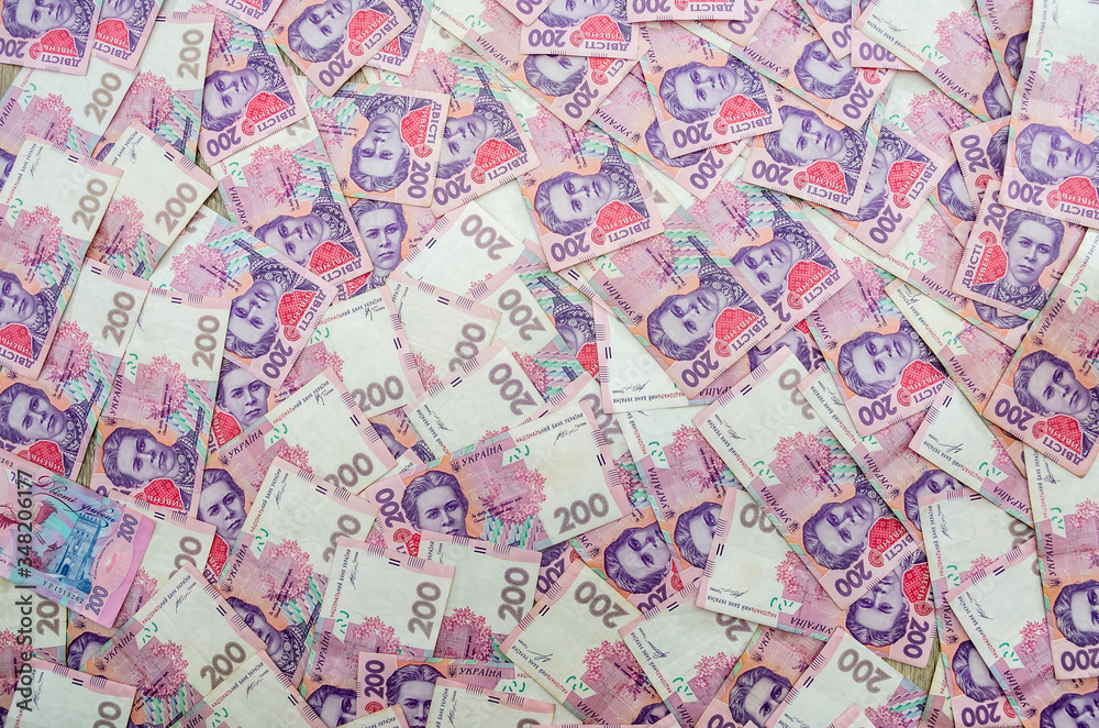 delicate background with banknotes of 200 hryvnia. A lot of hryvnia.
