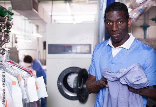 Male laundry worker sorting dirty clothes photo