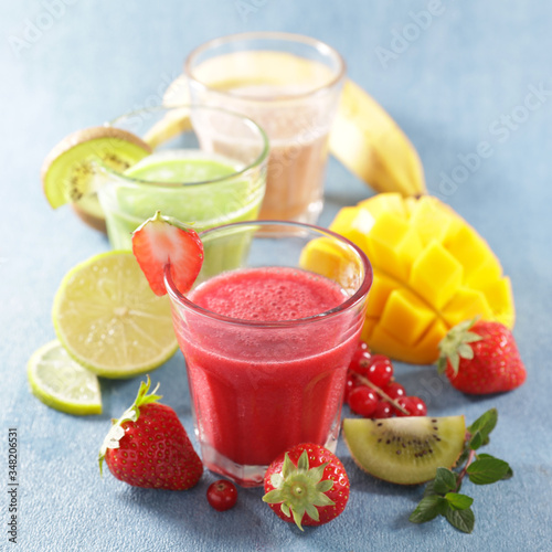 smoothie with fresh fruits on blue background