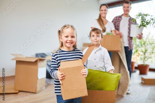 Children and parents carry moving boxes