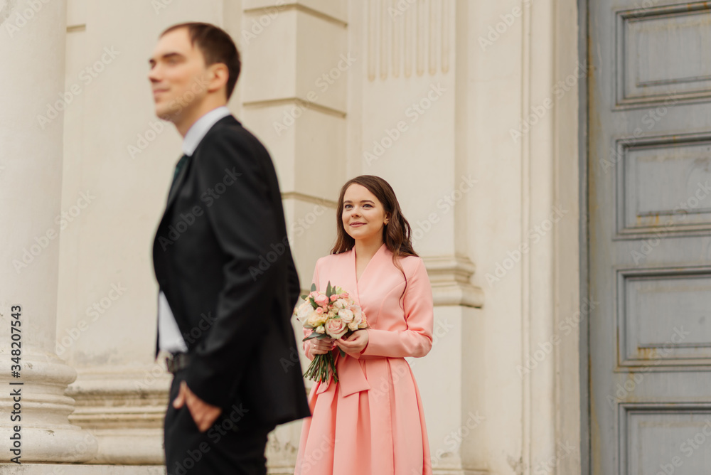 A beautiful wedding couple walks on a background old cathedral, wedding concept. A beautiful wedding couple walks on a background old cathedral, wedding concept.