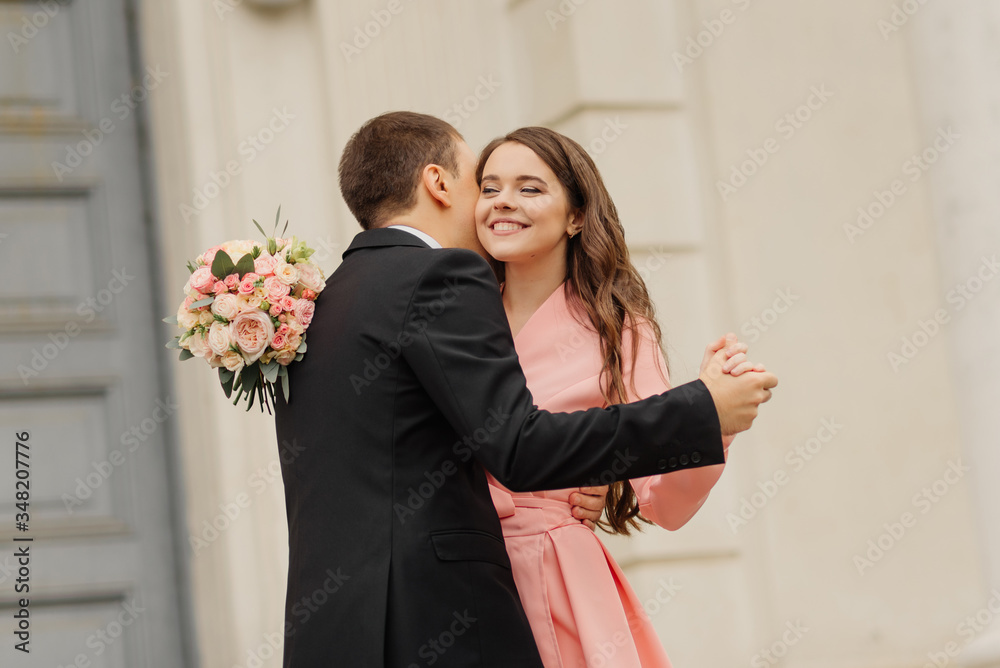 A beautiful wedding couple have fun and dancing against the background of an old architectural building. Wedding concept. A beautiful wedding couple have fun and dancing against the background of an old architectural building. Wedding concept.