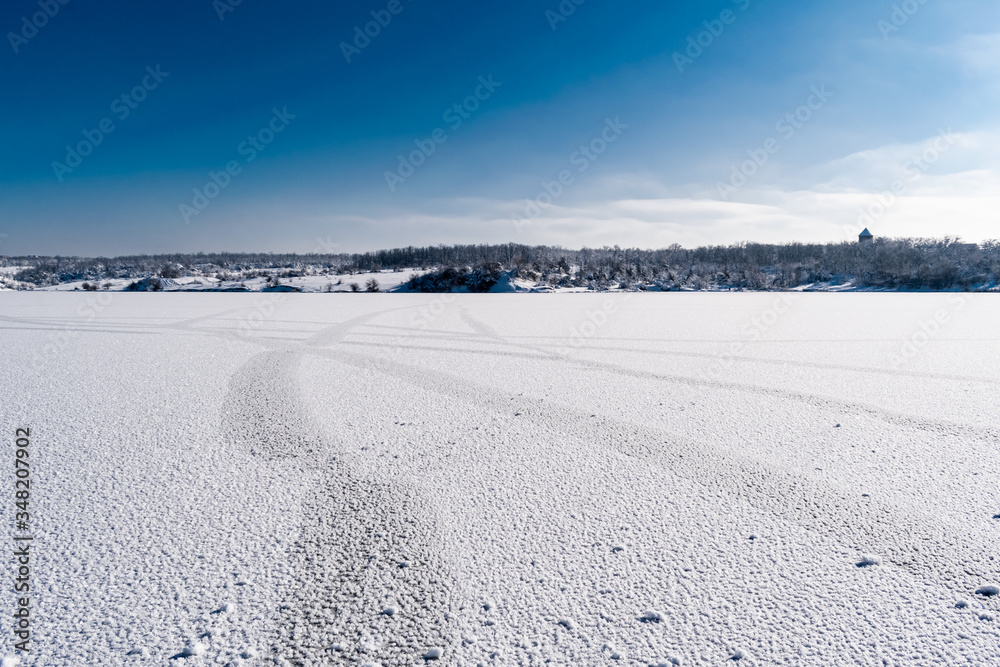 Spacious snow landscape. River and hills in Russia, white winter on the terrain, a lot of fluffy snow and ice under a beautiful blue sky. Rostov region, town of Shakhty, the river Grushevka Spacious snow landscape. River and hills in Russia, white winter on the terrain, a lot of fluffy snow and ice under a beautiful blue sky. Rostov region, town of Shakhty, the river Grushevka