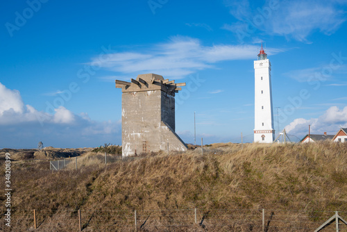 lighthouse in blavand denmark with bunker of the ww in the foreground photo