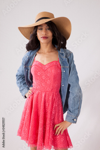 Thoughtful woman in a straw hat and blue jean jacket