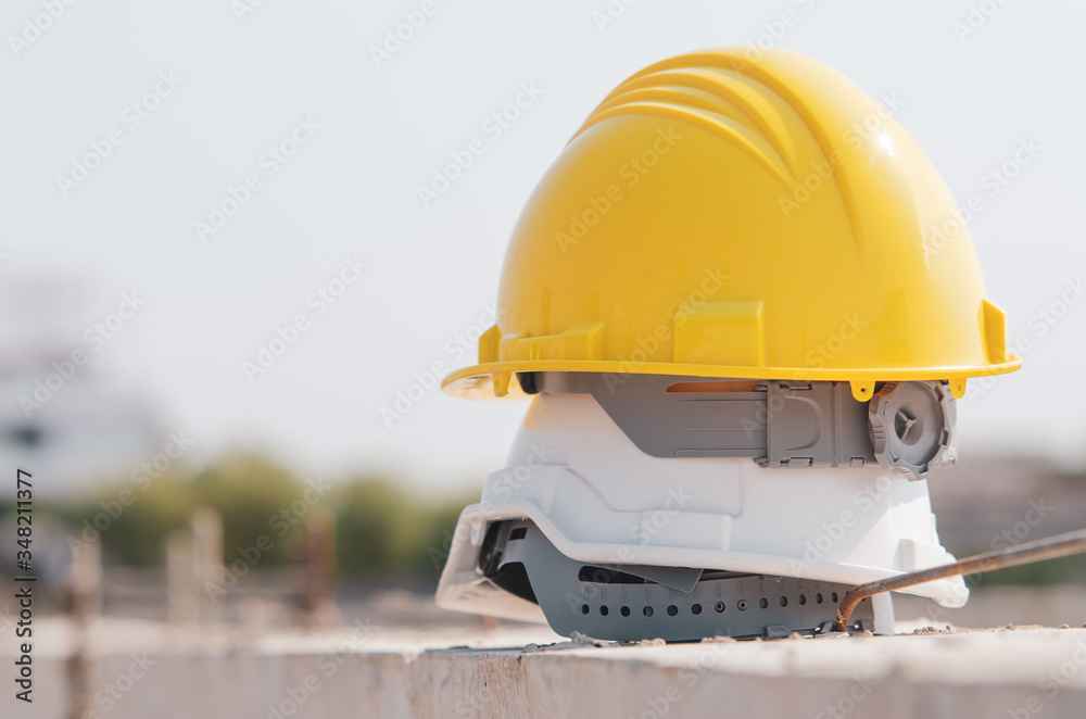 White and yellow helmet placed on the construction site.