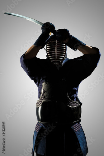 Male in tradition kendo armor with Samurai sword katana. shot in studio. Isolated on grey background