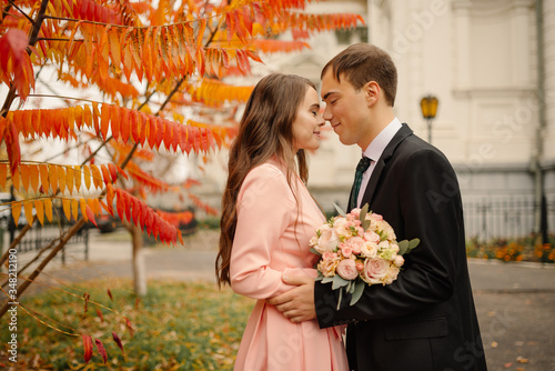 Wedding couple hugs in the old city at autumn. Stone walls of ancient church. Romantic love in vintage atmosphere street. Gothic cathedral.