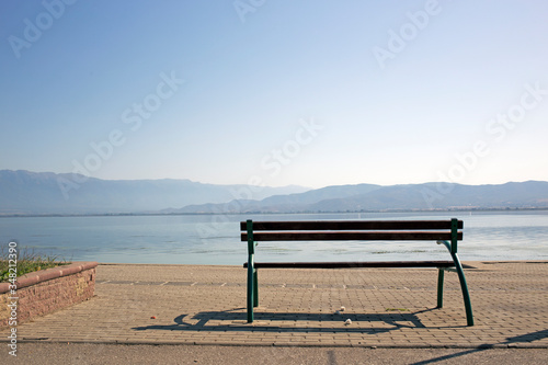 A bench silhouette overlooks the mountains surrounding Dojran Lake. Atmospheric Perspective.