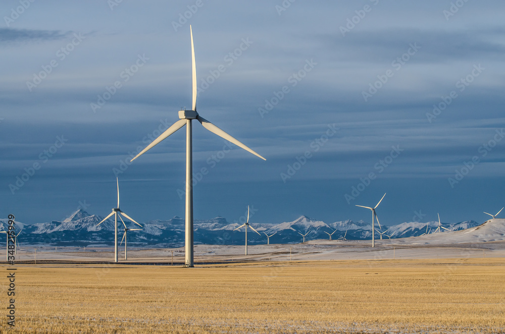 Wind Turbines in early morning light in spring with Rocky Mountains in the back ground Wind Turbines in early morning light in spring with Rocky Mountains in the back ground