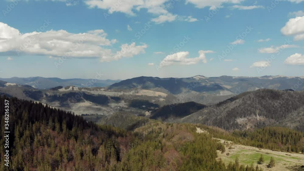 Flight over the summer Carpathian mountains at sunset.moving forward to pine woods forest and mountain valley with sun flare in summer day Flight over the summer Carpathian mountains at sunset.moving forward to pine woods forest and mountain valley with sun flare in summer day