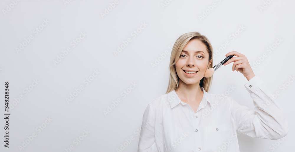 A pretty young woman is using different make-up accessories for application of make-up A pretty young woman is using different make-up accessories for application of make-up