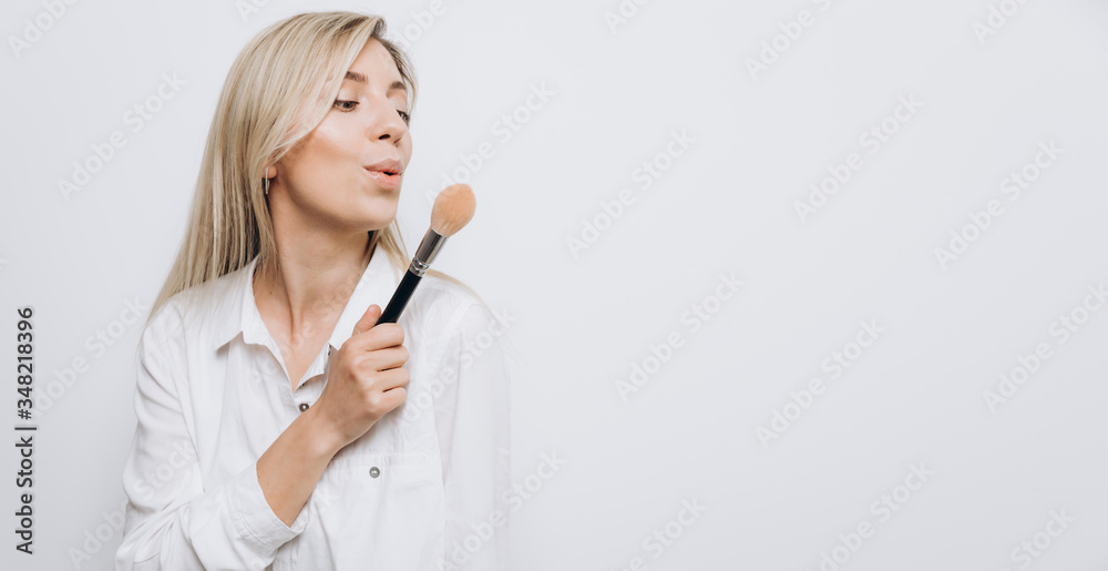 A pretty young woman is using different make-up accessories for application of make-up A pretty young woman is using different make-up accessories for application of make-up