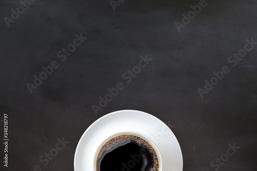 cup of coffee on black wooden floor background. top view