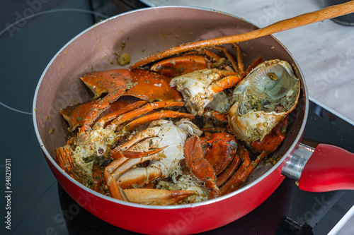 Homemade salt pepper crab on cooking pan and induction stove
