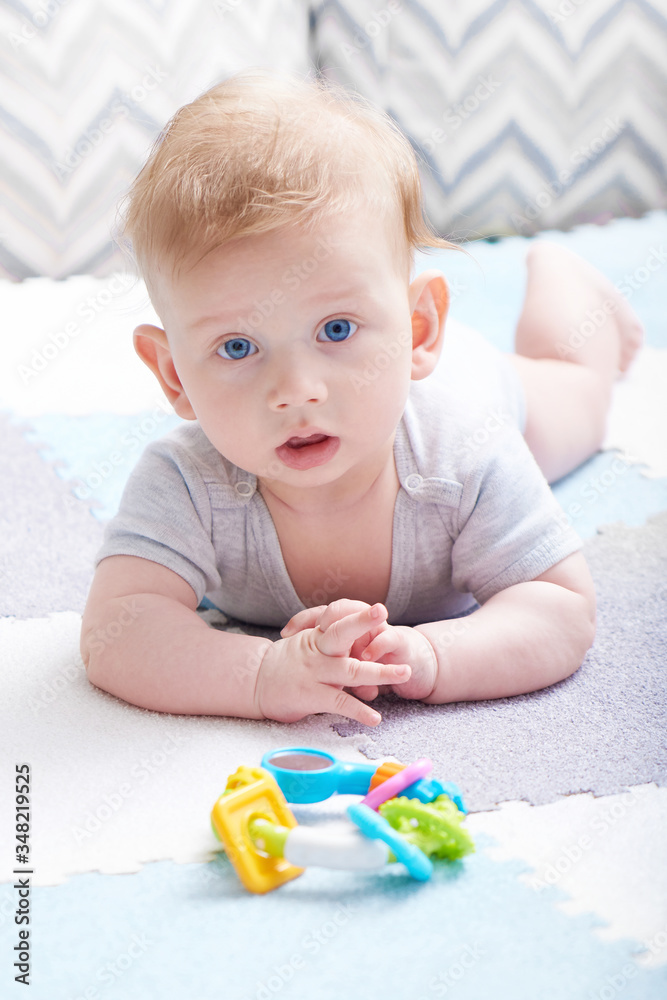The baby s teeth are being cut. A cute kid with blue eyes is playing with toy The baby s teeth are being cut. A cute kid with blue eyes is playing with toy