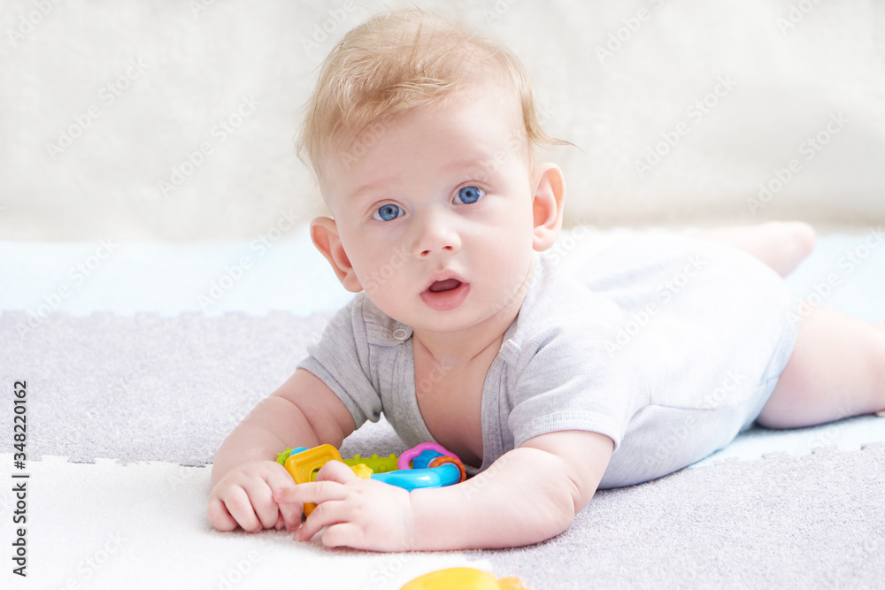The baby s teeth are being cut. A cute kid with blue eyes is playing with toy The baby s teeth are being cut. A cute kid with blue eyes is playing with toy