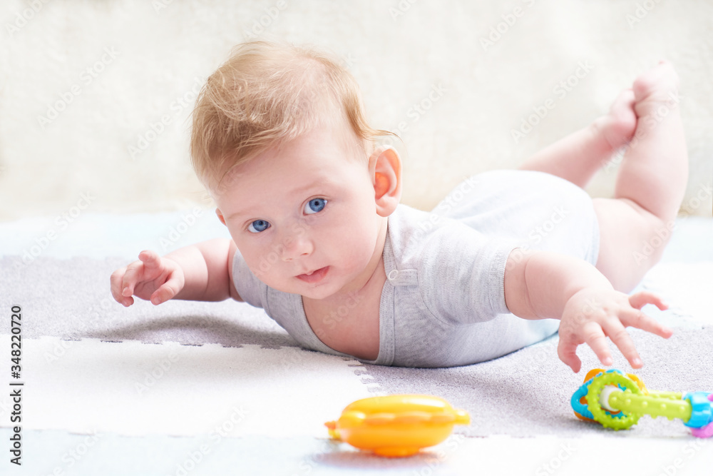The baby s teeth are being cut. A cute kid with blue eyes is playing with toy The baby s teeth are being cut. A cute kid with blue eyes is playing with toy