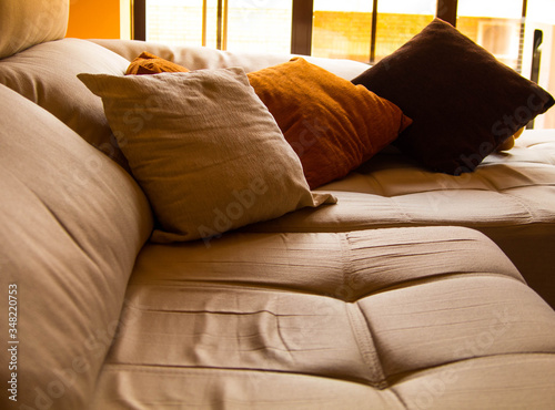 beige and orange cushions in living room with bay window