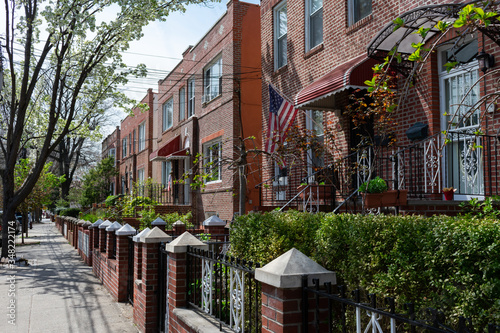 Fotografie, Obraz Beautiful Row of Old Homes along a Sidewalk during Spring in Astoria Queens New
