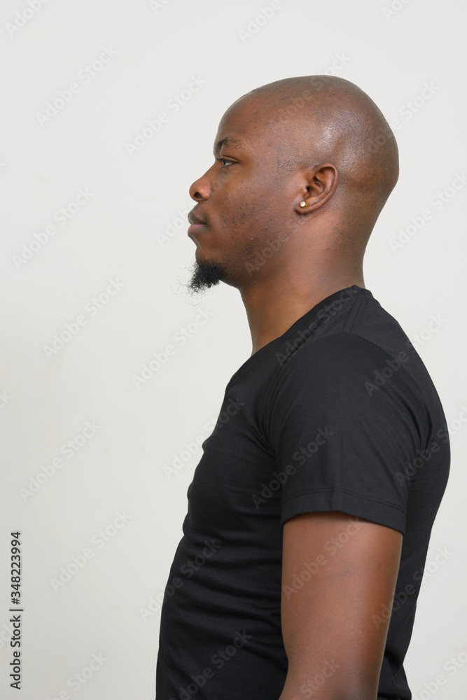 Profile view of young handsome bald African man Profile view of young handsome bald African man