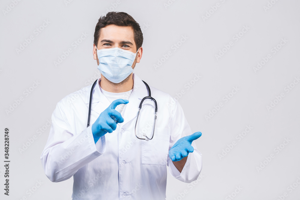 Doctor man in gown face mask gloves isolated on white background. Epidemic pandemic coronavirus 2019-ncov sars covid-19 flu virus. Bottle with alcohol liquid antibacterial sanitizer.