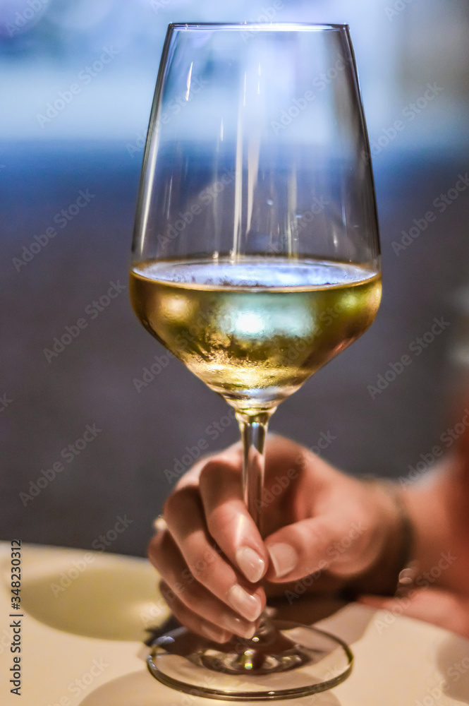 woman hand holding a glass of white wine