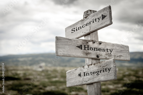 sincerity honesty integrity text engraved on old wooden signpost outdoors in nature. Quotes, words and illustration concept. photo