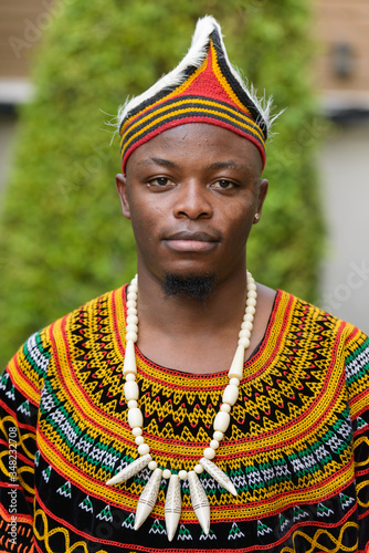 Face of young handsome African man wearing traditional clothing outdoors